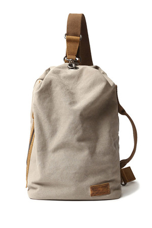 Retro plátěný batoh nebo taška ve tvaru vaku s detaily z pravé hovězí kůže v módním retro designu. Hlavní oddíl